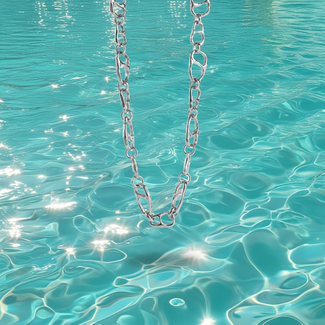 Collier Mahei Bahari en acier inoxydable argent à maillons irréguliers, photographié devant la mer