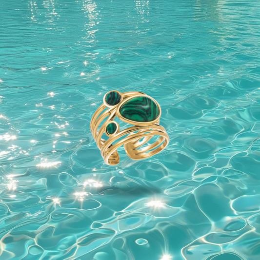 Bague Mouroud dorée réglable avec pierre verte sur fond marin, bijou original pour femme.