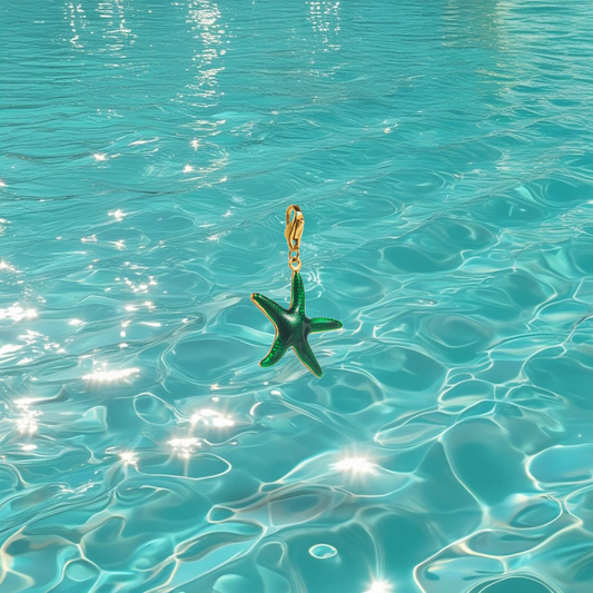 Charms étoile de mer Najma Bahari en acier inoxydable doré vert, photographié devant la mer