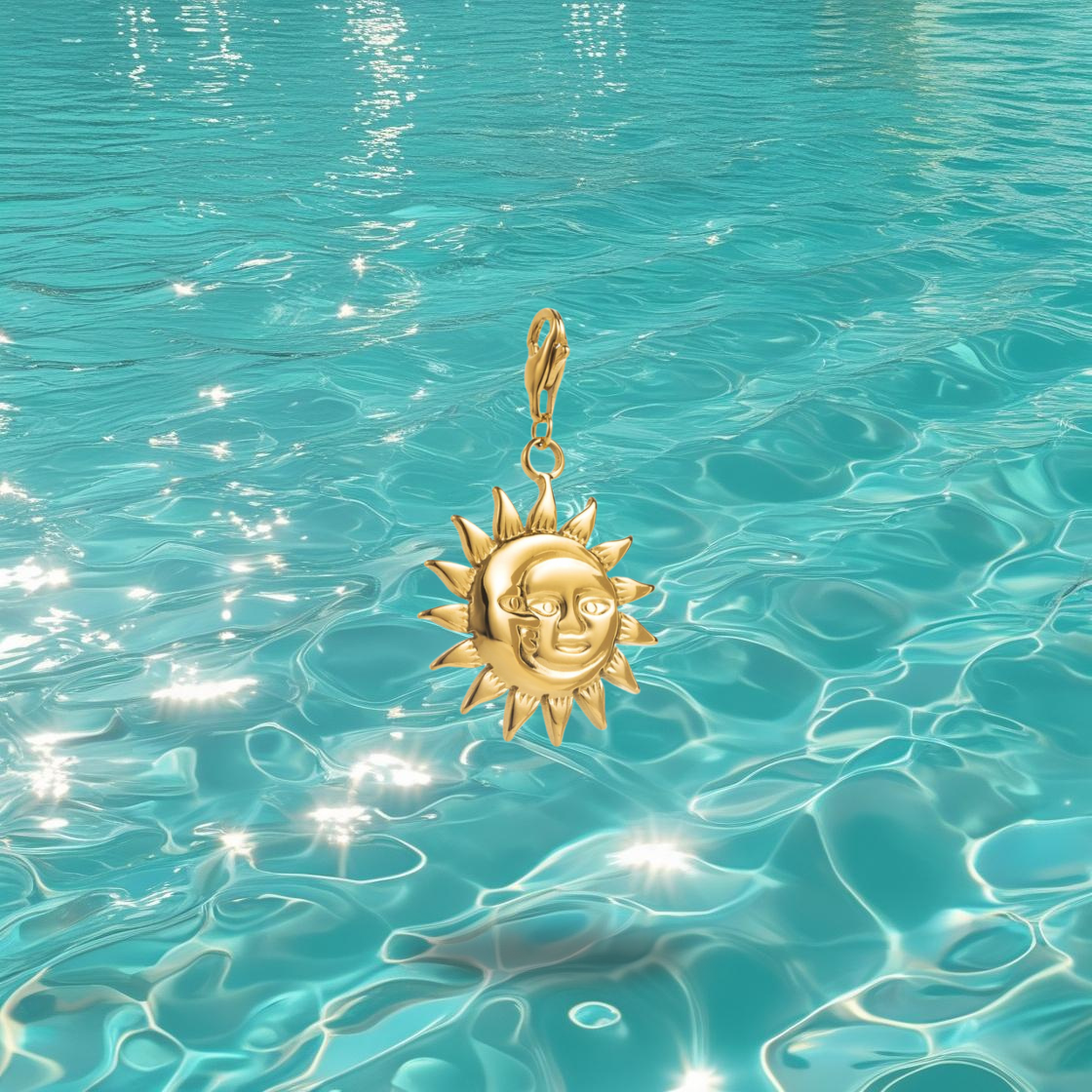 Charm soleil Shemsa Bahari en acier inoxydable doré, photographié devant la mer